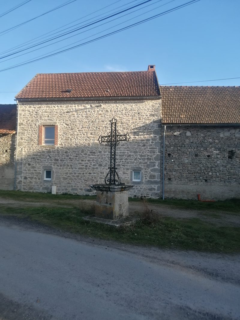 Croix en fer forg&eacute; devant maison en pierre aux Picouts